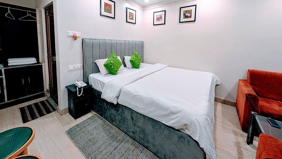An image of a Cottage Room featuring a double size bed, bedside table, a seating area with sofa and table, and a wardrobe at Rangamati Garden Resort