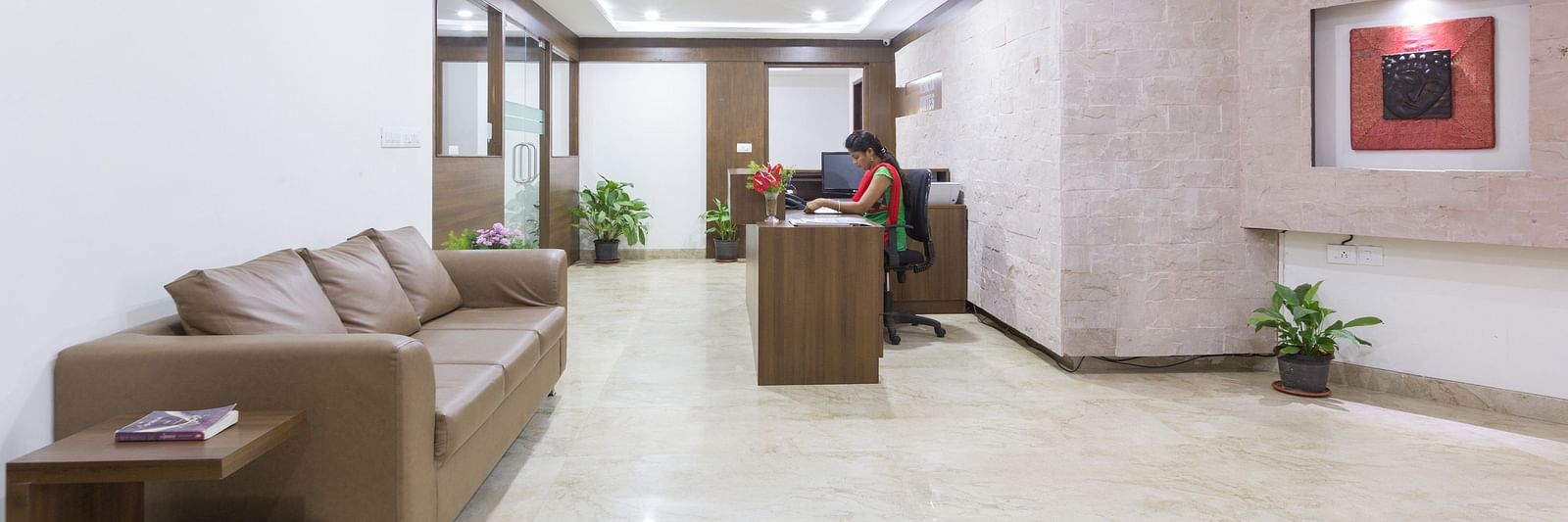 A lobby area with cushioned sofas, a coffee table, and decorative lighting on the ceiling - Sanctum Suites BEL Road, Bangalore