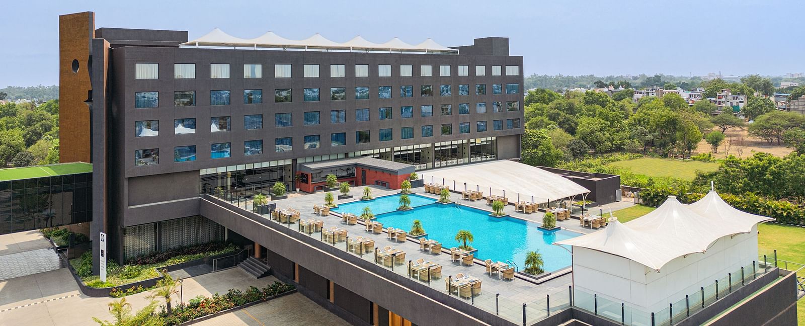 Exterior with the swimming pool in view of Essentia Luxury Hotel, Indore, during the day.