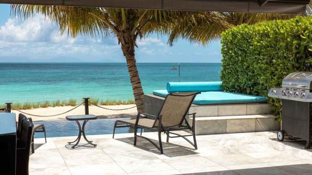 Ocean-view seating area under a shaded canopy at Tamarind Hills Antigua – Resort & Villas, perfect for relaxing by the sea