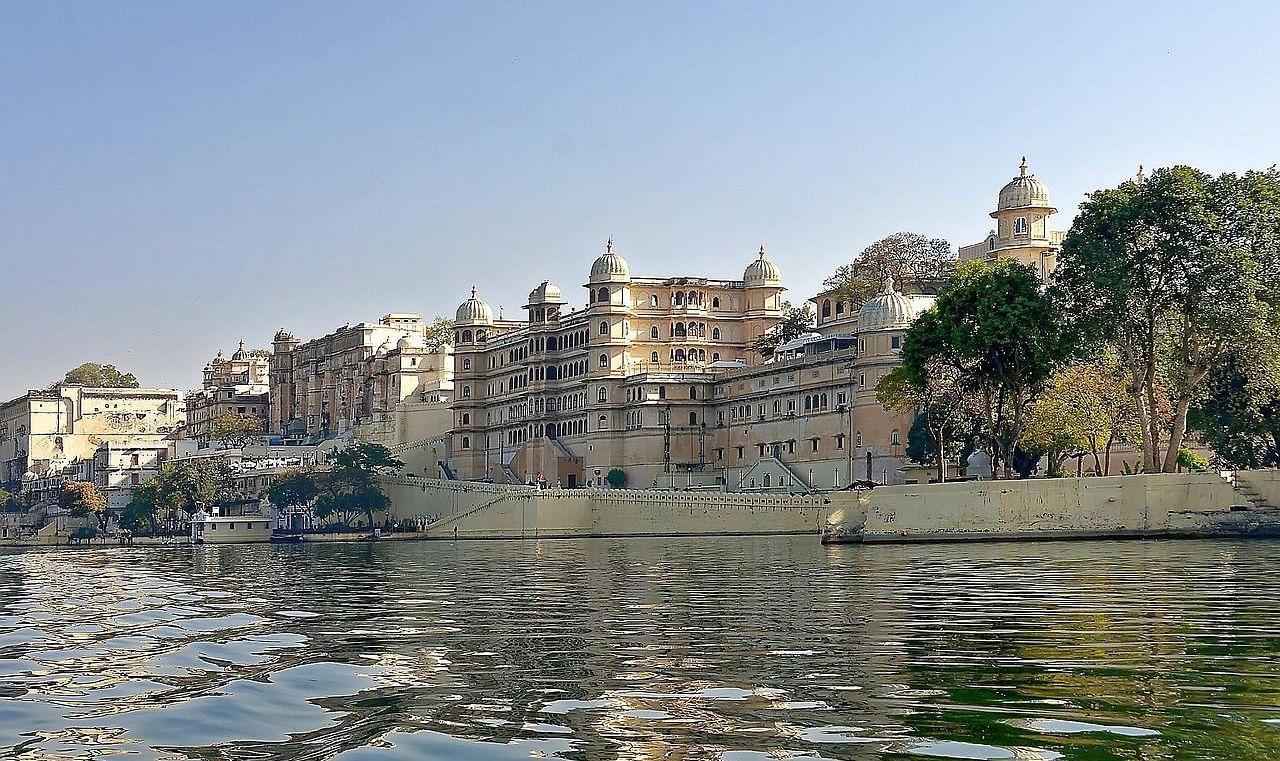 A lower angle view of a palace from the lake point with clear blue sky in the background.
