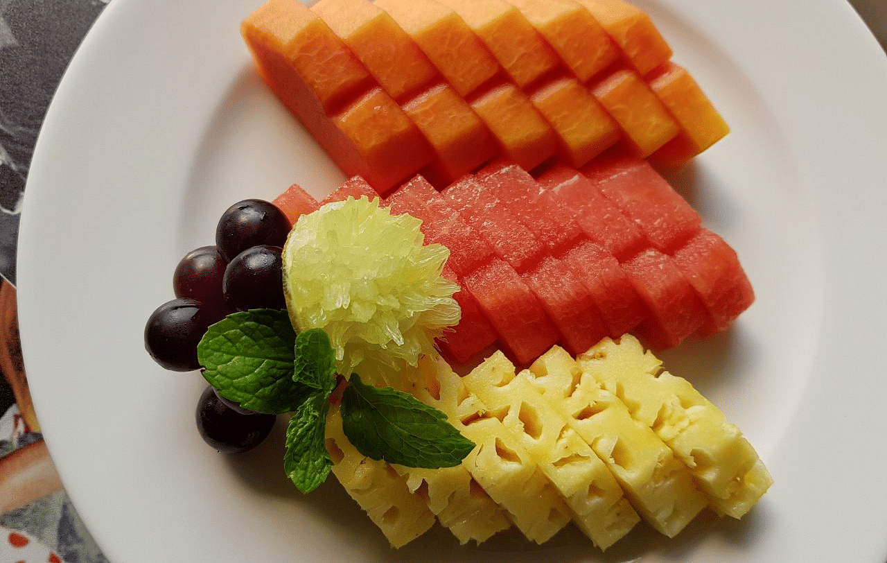 Various fruits cut in a pattern arranged on a plate