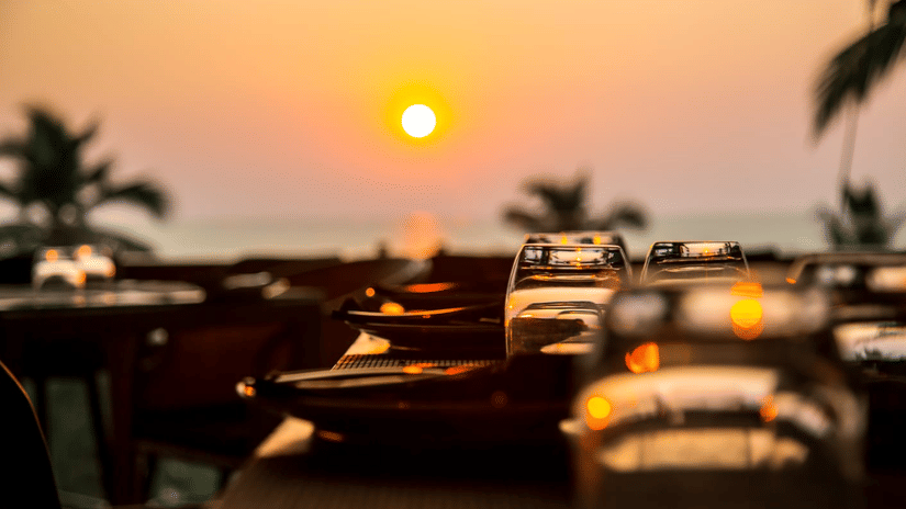 sunset view can be enjoyed from a restaurant open dining area with empty tables - Stone Wood Hotels & Resorts