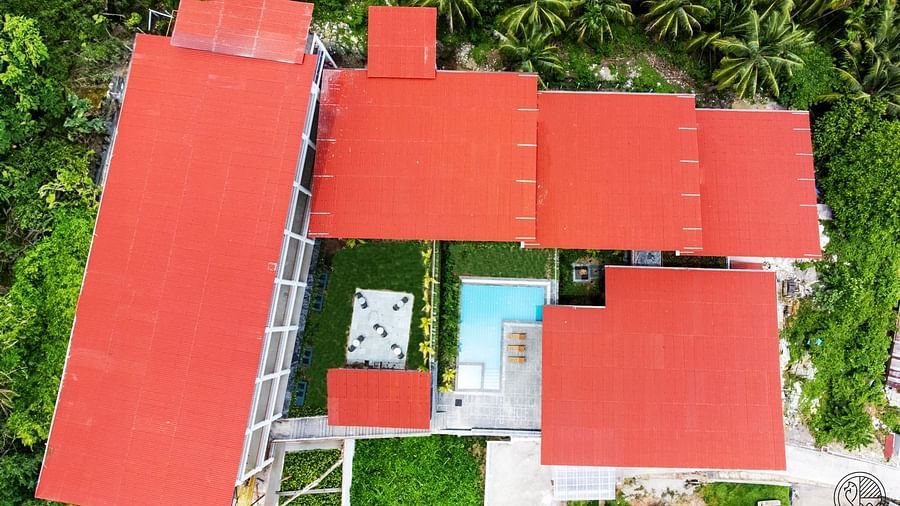 An aerial shot of a hotel complex with red roofs and a swimming pool, nestled among green trees. - Sea Hills Resort, Swaraj Dweep (Havelock)