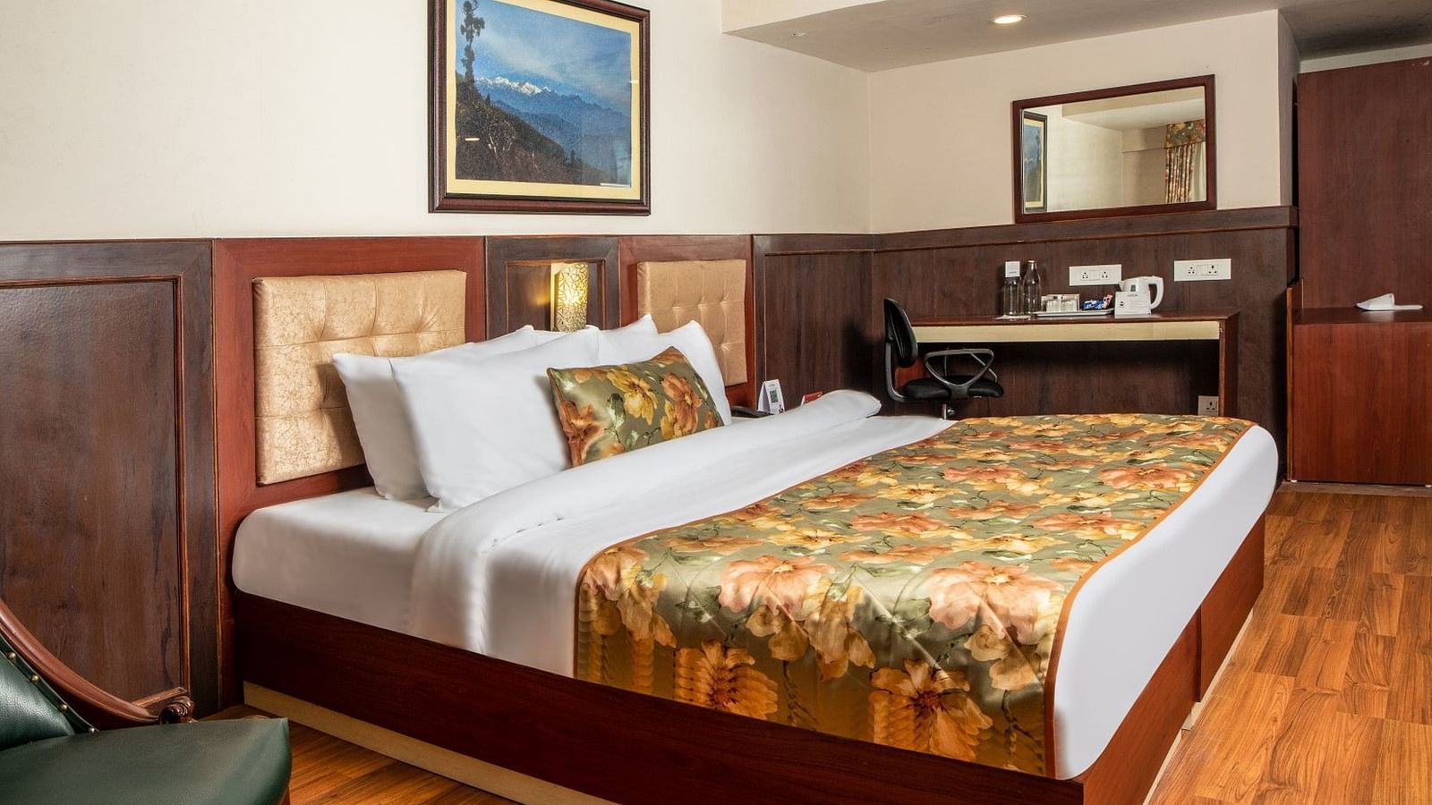 A side view of a bed in a room that has a chair and work desk | Summit Oakden Resort & Spa, Mall Road