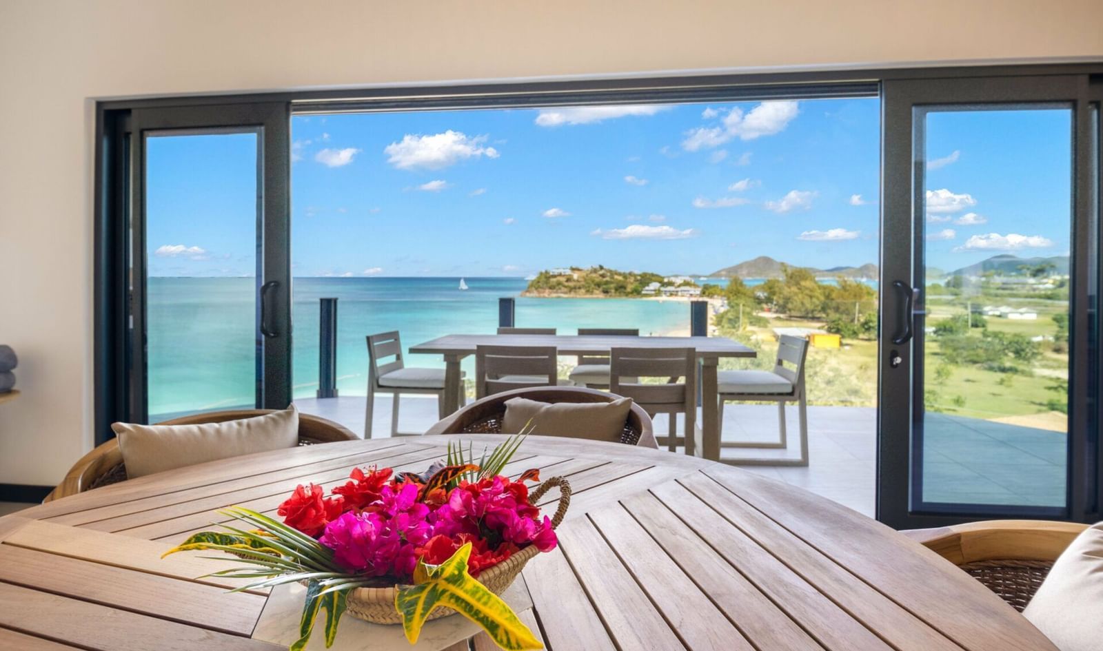 A beautiful al fresco dining area with a stunning view of the turquoise sea and distant hills - Tamarind Hills Resort and Villas - Antigua