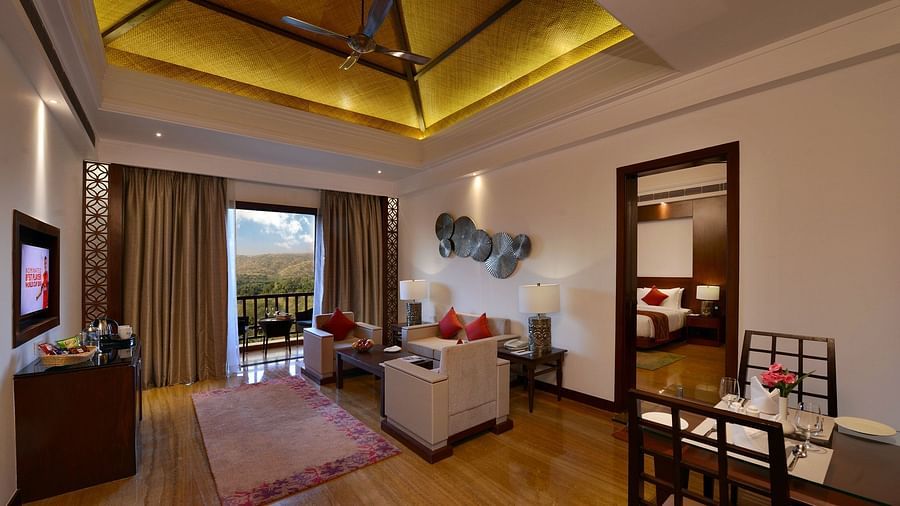 The living room area with a door leading to the balcony inside the executive suite - The Ananta Udaipur