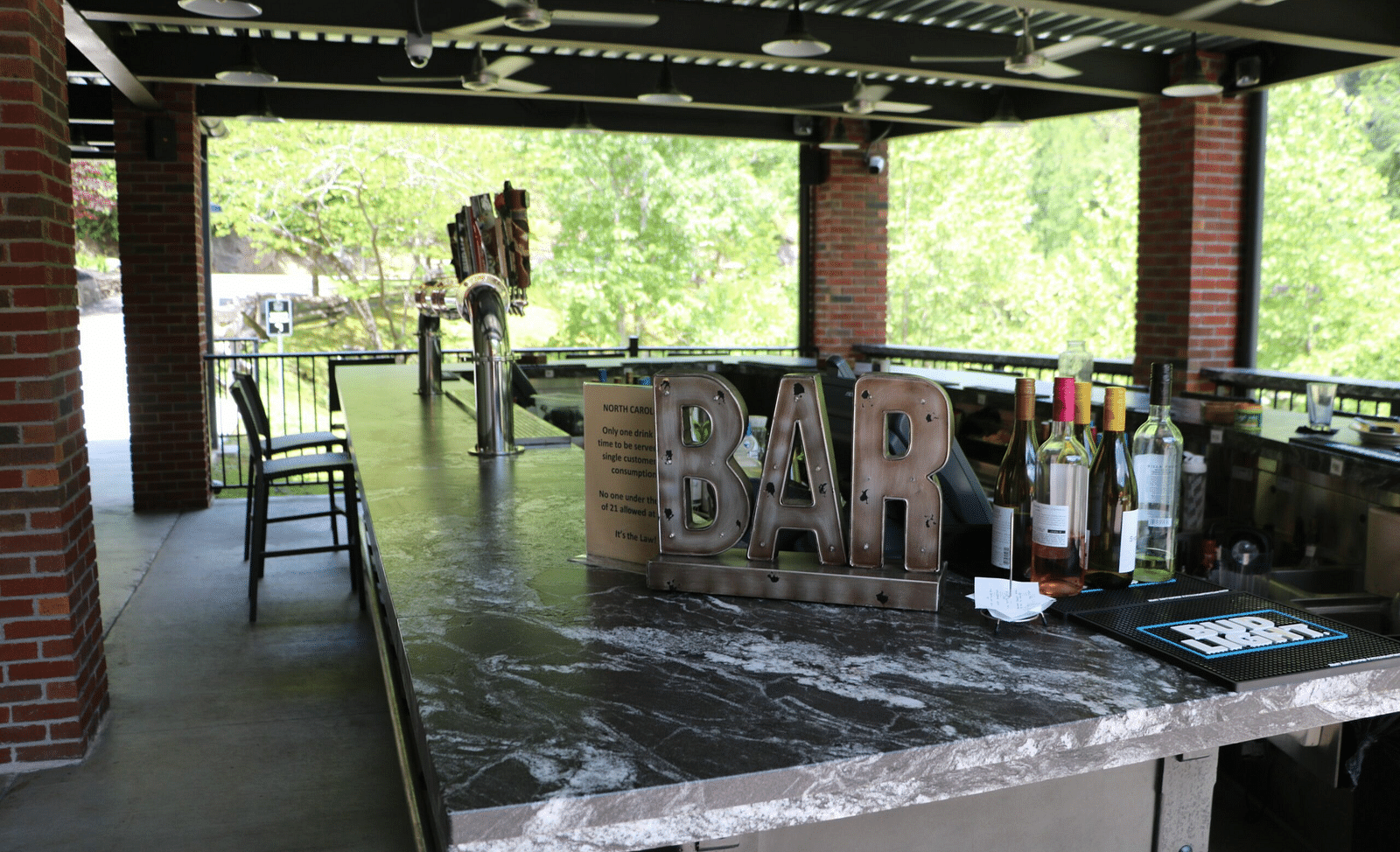 an open bar with a variety of alcoholic bottles on display kept on the counter - Historic Tapoco Lodge