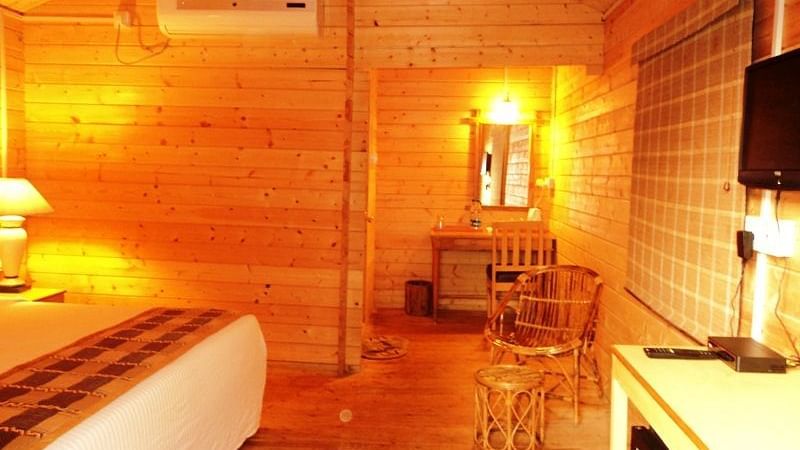 The warm and wooden furnished room with plaushy bed at Lotus Eco Beach Resort, Konark.