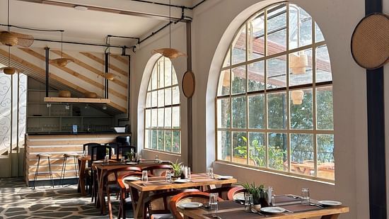 Indoor seating at a restaurant with wooden furniture and a partially visible counter. - VITS Select Kunjham, Gangtok