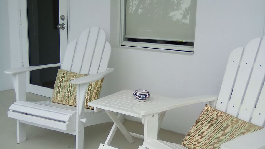 Outdoor seating area at Casa Morada with two white chairs and beige cushions