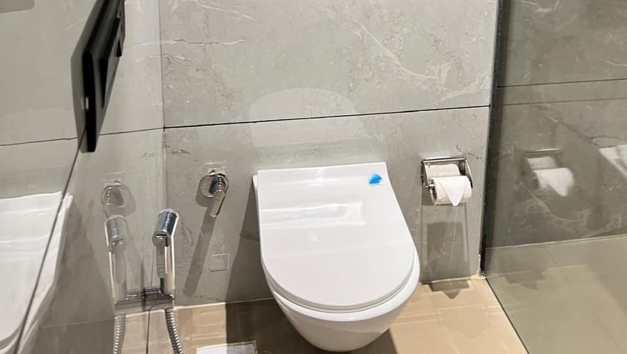 Stylish bathroom at Hotel Mumbai House, Vijay Nagar, Indore, featuring modern fixtures, glass shower cabin, and elegant tiled finishes.