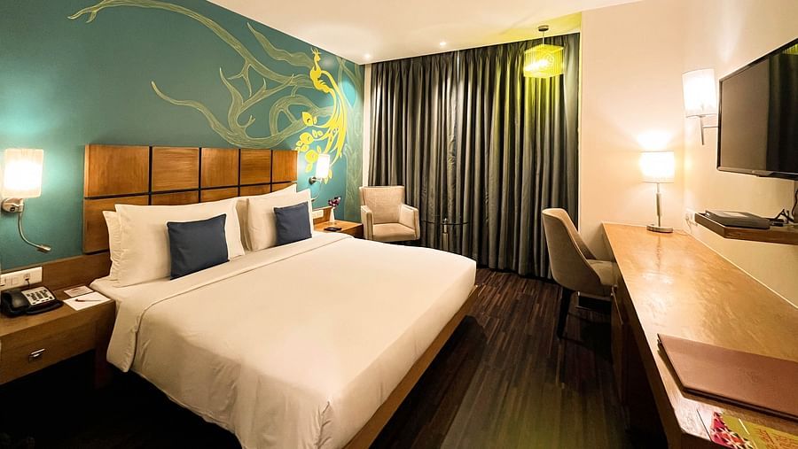 Deluxe Room at The Beatle Hotel, Powai, featuring a modern design with a peacock-themed wall mural.