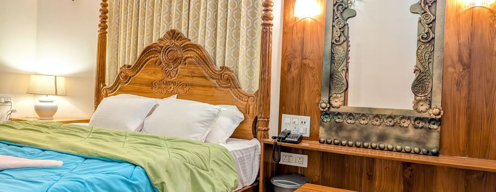 A corner view of a  double bed at the pool side cottage at dip holidays along with a dressing table besides it