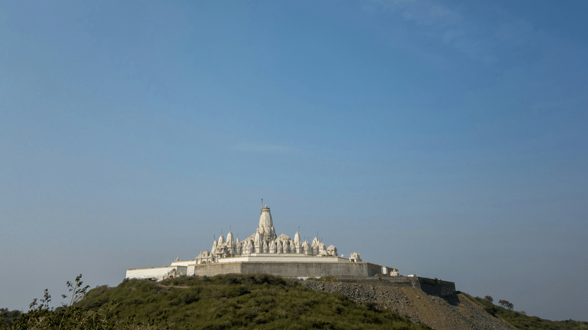 Parasnath Jain Temple on a hilltop as seen from afar with blue sky in the background - Parasnath Jharkhand