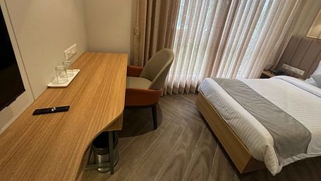 side view of a deluxe bedroom with sheer curtain at  Hotel Mumbai House Mindspace Malad