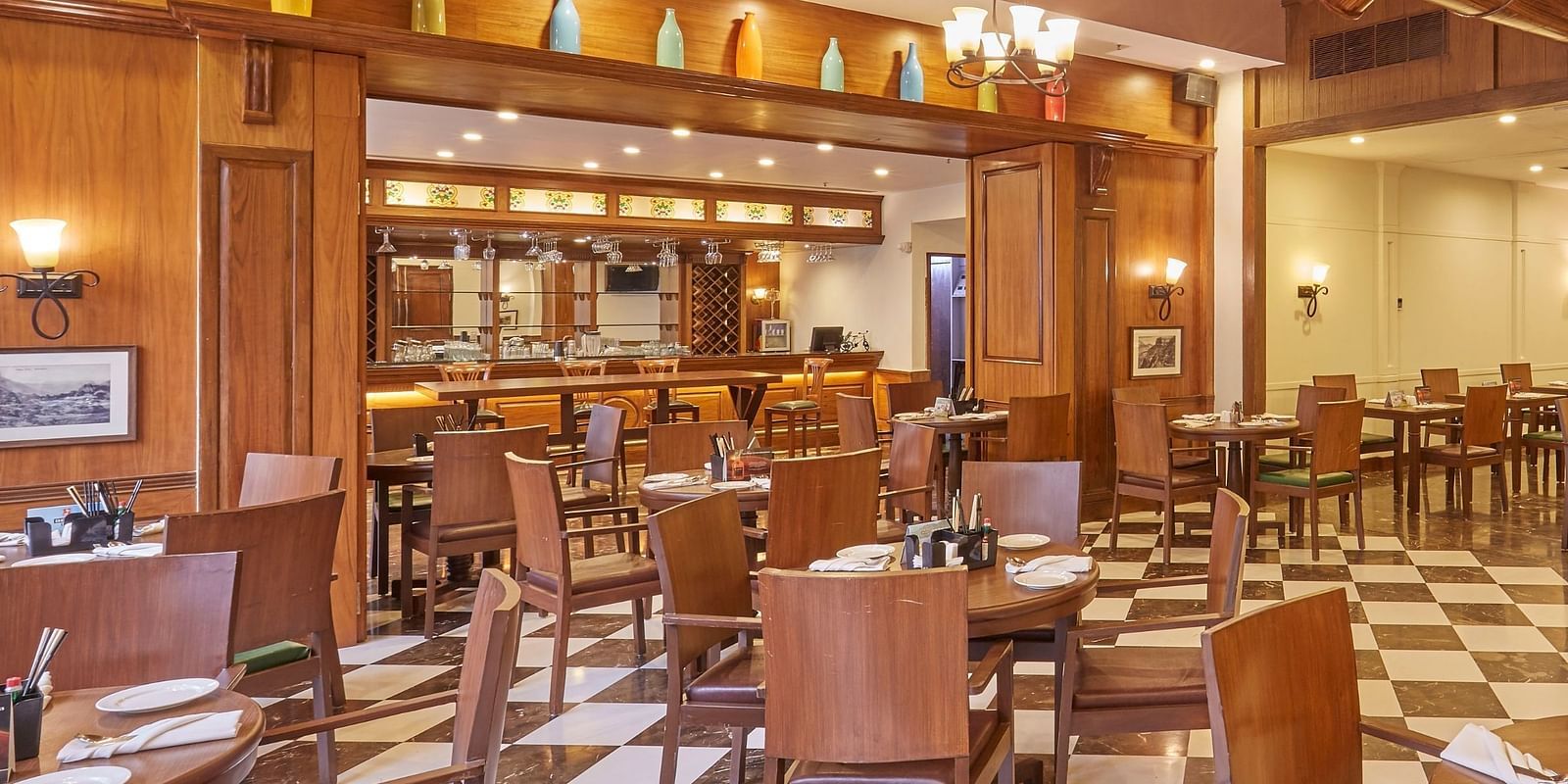 An overview of Cedar restaurant featuring wooden interiors and an elegant dining arrangement - Rhythm Lonavala