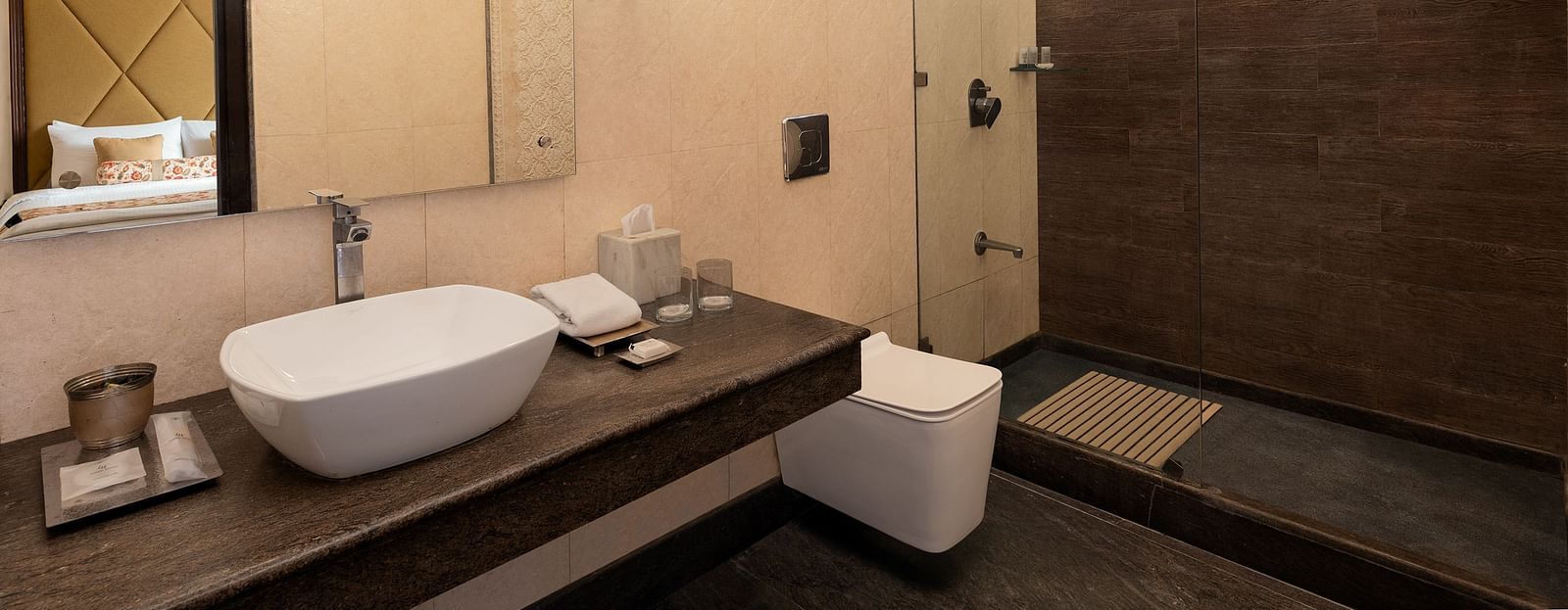 An image featuring a washroom, a big mirror,  the glass separator for bath area - The Naini Retreat, Nainital.