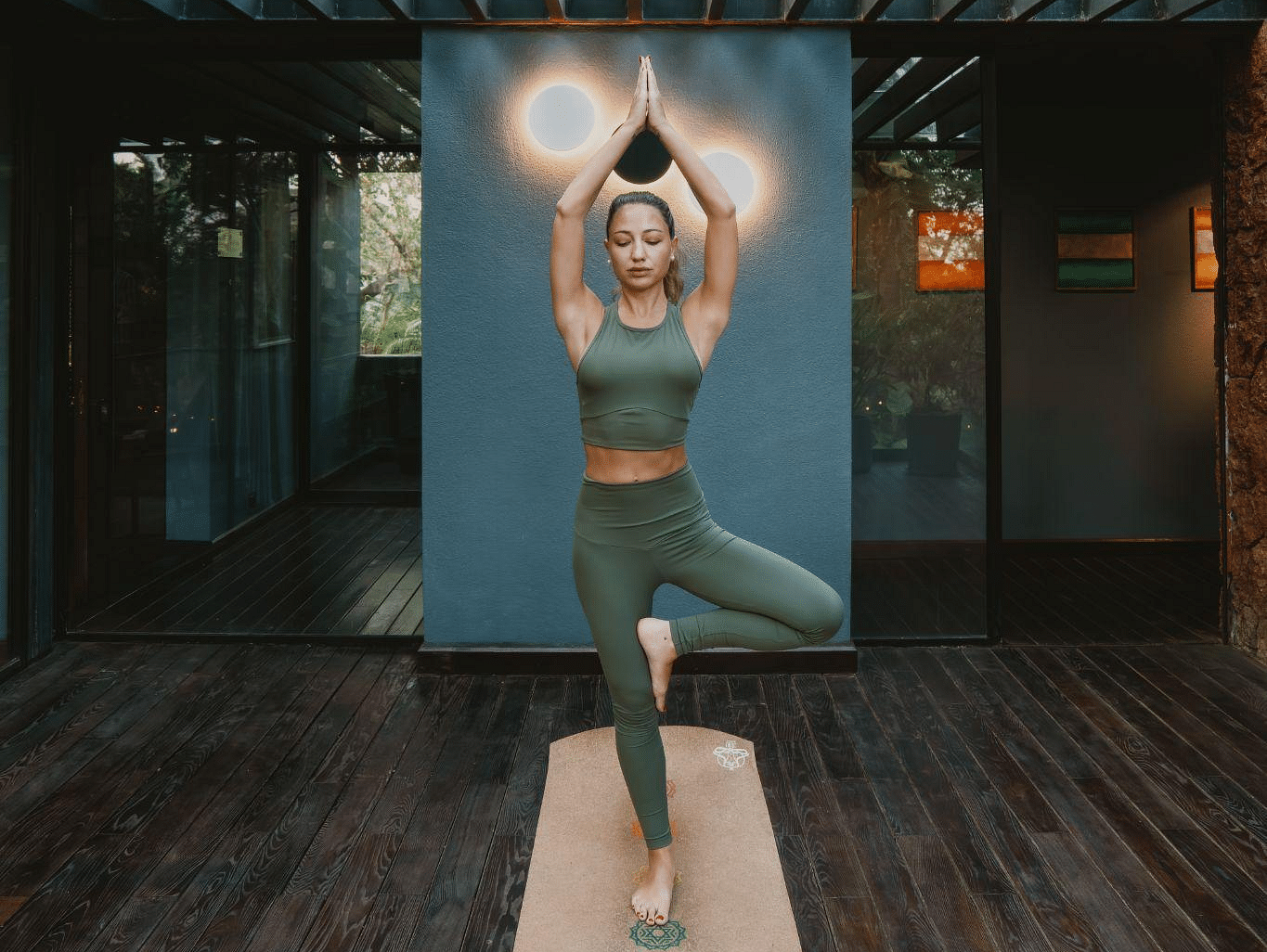 A picture of a women performing yoga on a mat in a room
