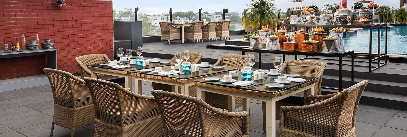 Dining area by the side of the pool at Essentia Luxury Hotel, Indore