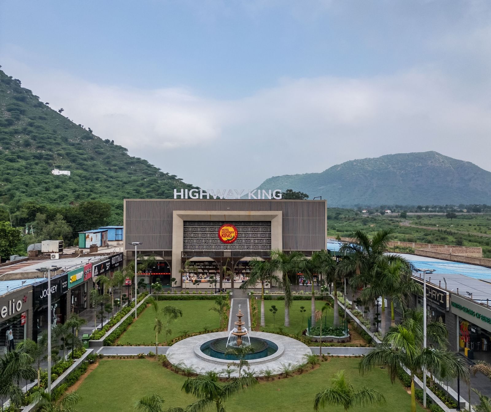 The main building entrance and formal landscape garden area at Hotel Highway King, Neelka.