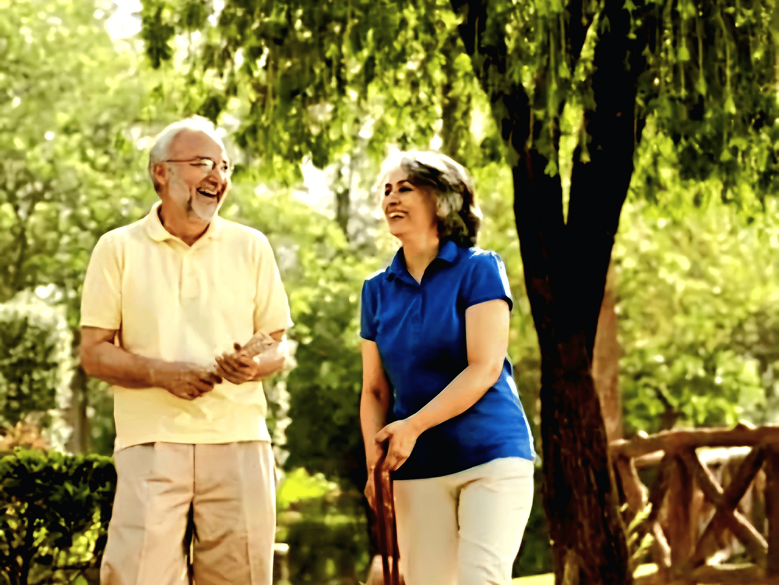 An old couple wearing western attire, walking a dog in a lush green park | Vedic Village Spa Resort