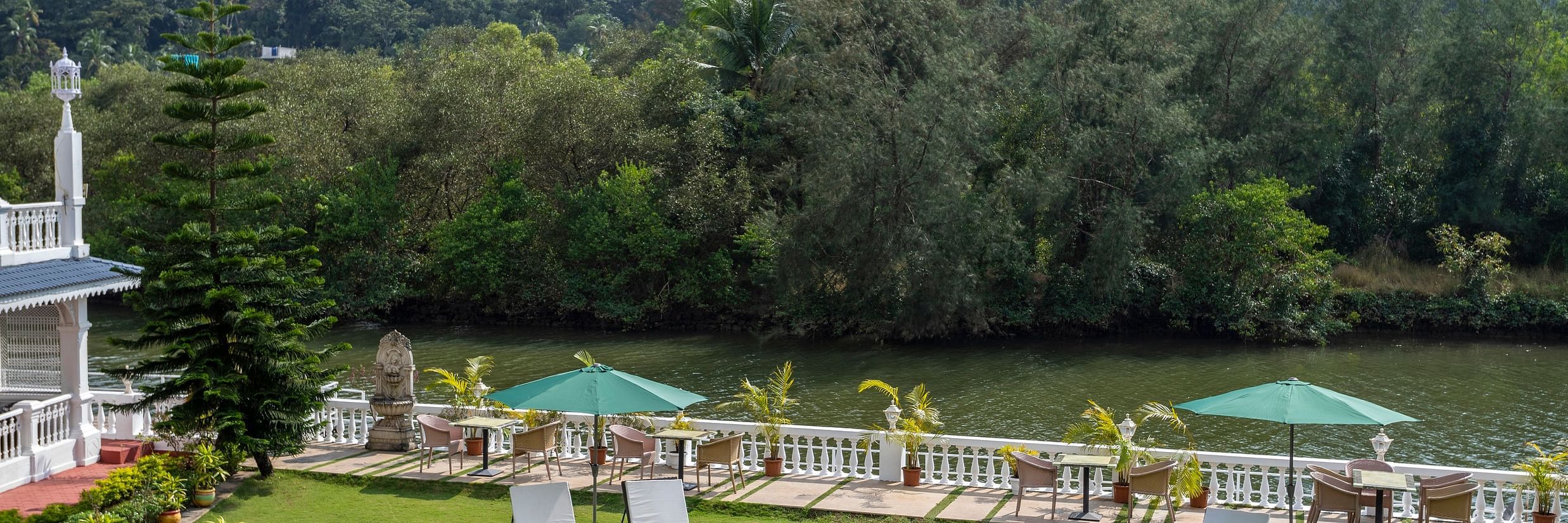 The Riverview outdoor seating arrangement amidst lush green scenery - Stone Wood Riverfront Resort, Siolim