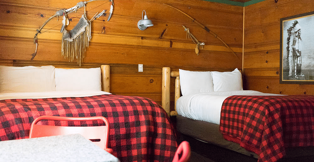 A wooden cabin with twin beds at Shaver Lake Village Hotel.
