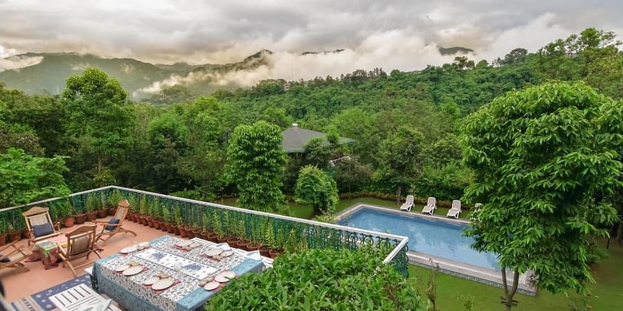 An aerial view showing a dining area on a terrace and a pool