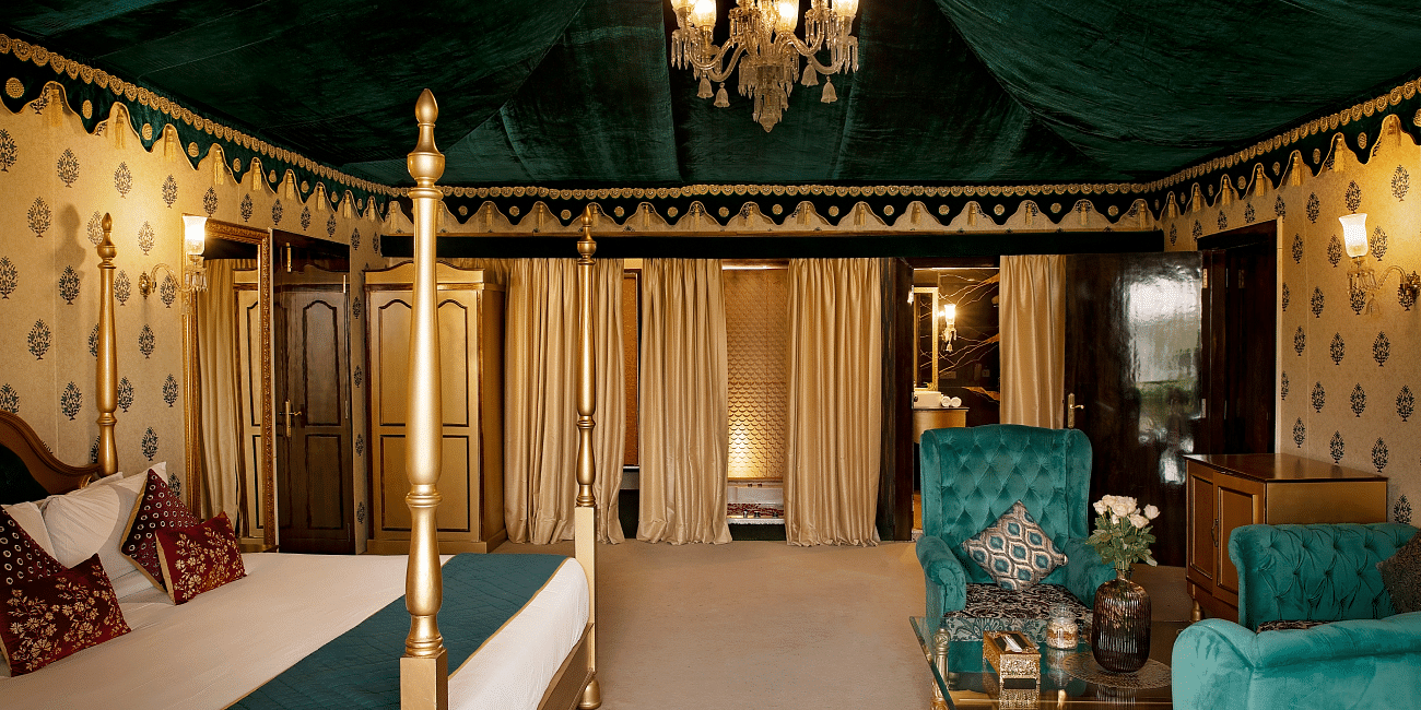 Side view of a room with a bed and a seating area in front at Rajasthali Resort & Spa Jaipur.