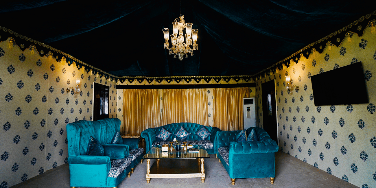 Image of a room with a seating area and a chandelier hanging from the wall at Rajasthali Resort & Spa Jaipur.