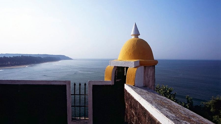  A close-up view from a high vantage point, showing a yellow domed structure in the foreground, with part of a building's roof and railing visible.