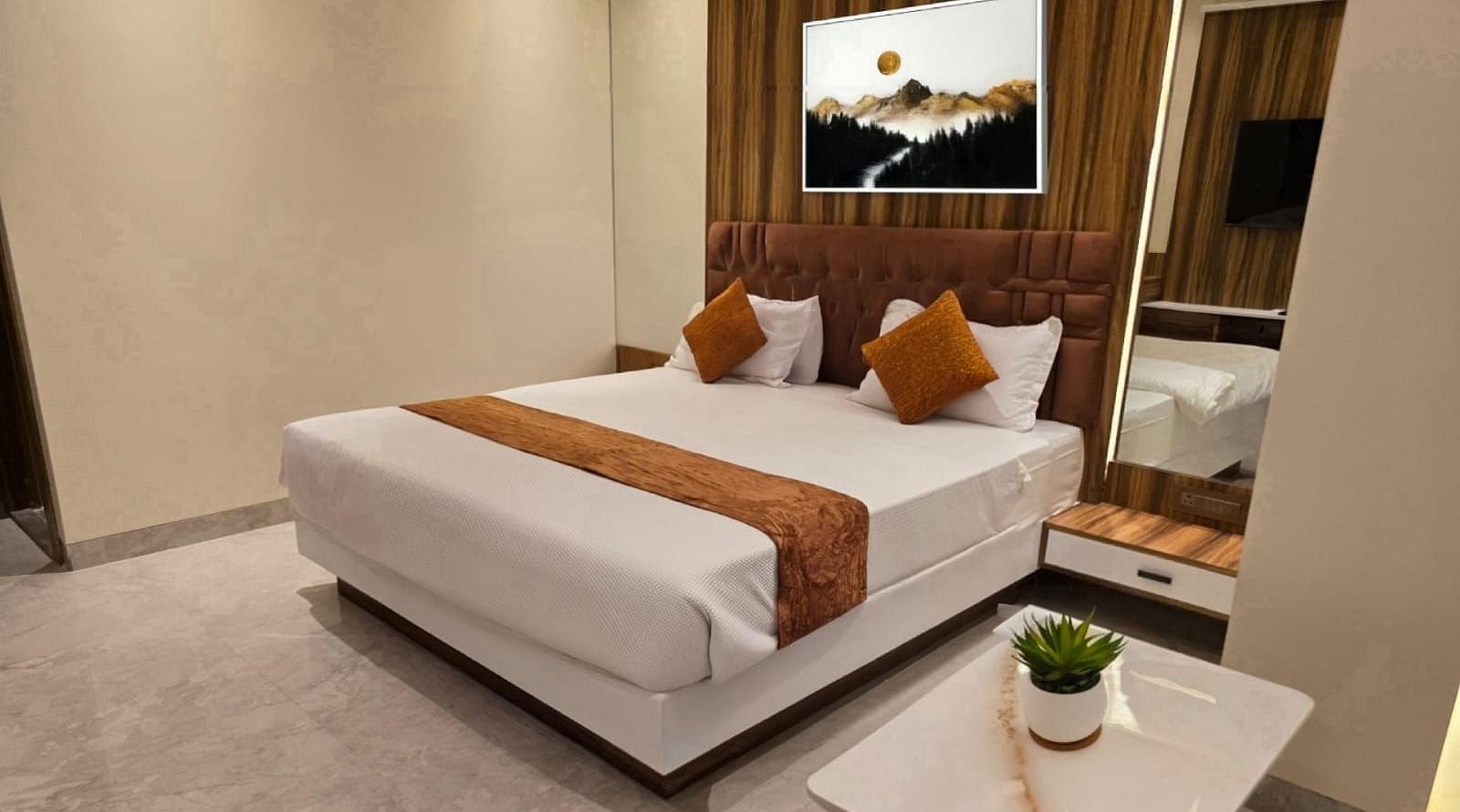 A bedroom with a portrait above the bed at Hotel Mumbai House, Vashi.