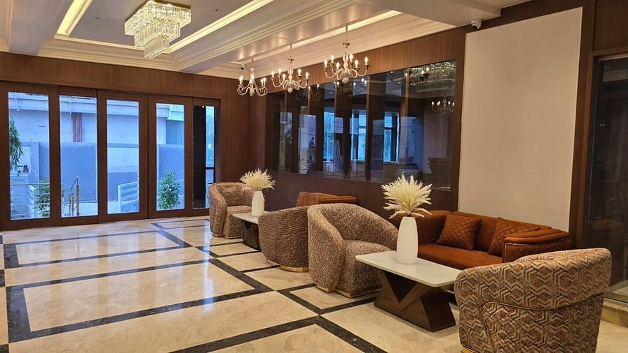 Lobby with stylish seating arrangements and elegant hanging lights from the ceiling at Hotel Mumbai House, Vashi.
