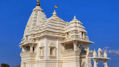 A temple stands with a spire and carvings under the sky.