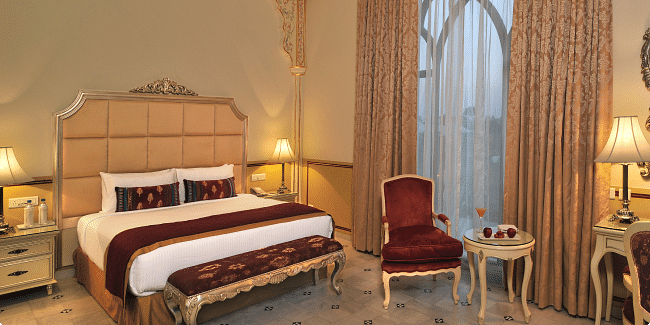 Image of a room with a bed and a chair on the side at Rajasthali Resort & Spa Jaipur.