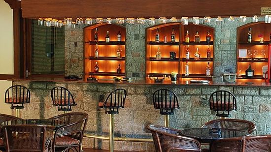 a bar table with bar stools in front of it inside Tusker Bar, Bar in Coimbatore - Black Thunder, Coimbatore