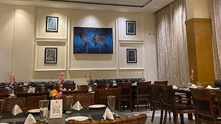 Full view shot of the Gold Plate restaurant with several photo frames wall mounted behind the dining tablesCorner view shot of the dining area of the Gold Plate restaurant with central air-conditioning and a small cabinet in the corner of the restaurant - 