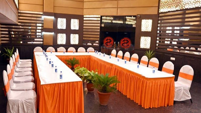 A huge table with orange coloured cloth covering the table set up for a conference in our conference hall at Hotel Gold, Panipat.