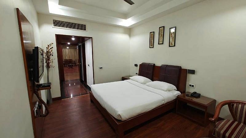The bedroom of the Suite featuring a plush double bed with minimalist interiors - Hotel Gold, Panipat