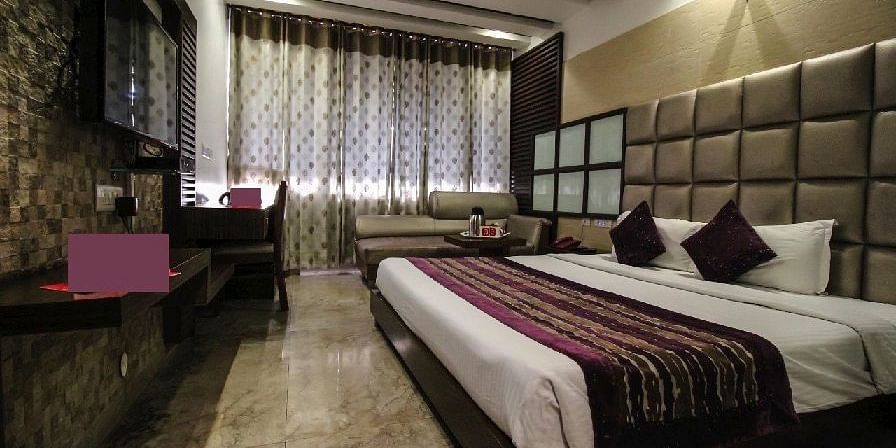 A beautifully designed hotel room with a large bed, rich colour tones, and a luxurious atmosphere - Hotel Emerald, Chandigarh