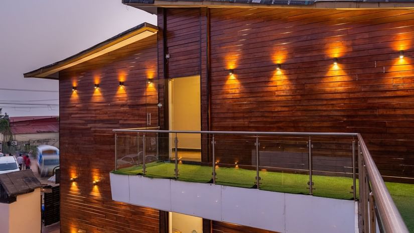 Exterior of Amara Oceanfront Resort, Baga, with an outdoor swimming pool, and chic lighting on the sides of the building.