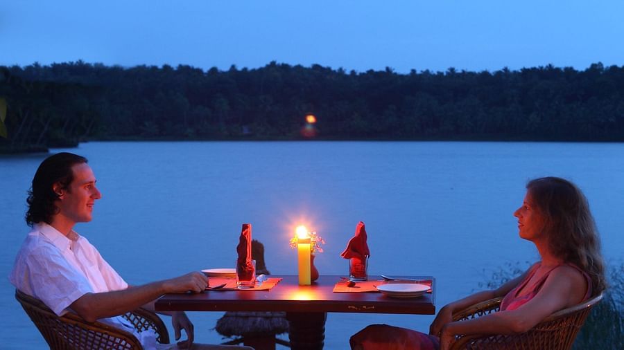 A couple enjoying a candlelit lakeside dining setup with a breathtaking view