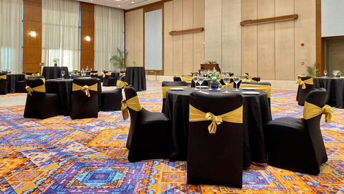 Round table seating inside the grand ballroom with lights shining down - karma lakelands.