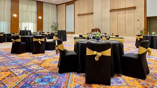 Round table seating inside the grand ballroom with lights shining down - karma lakelands