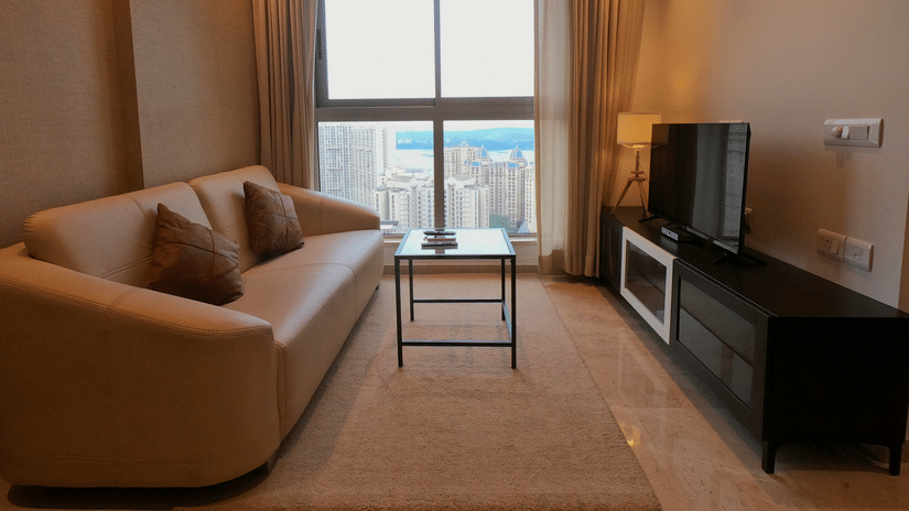 View of illuminated living area with sofa coffee table and TV set - Maxxvalue Apartment, Hiranandani, Powai