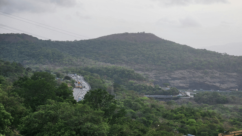 A landscape view of a lush green mountain range under a cloudy sky.