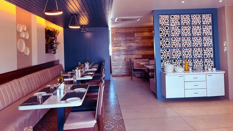 Image of a restaurant with a dining space and flowers mounted on the wall at Clarks Inn Express, Udaipur