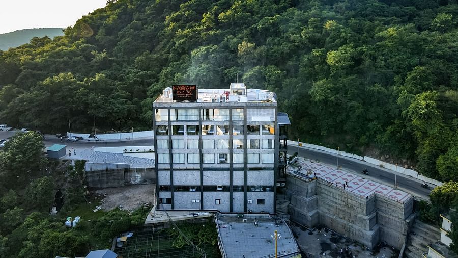 An image showcasing the elegant building of NAMAMI BY ZENQ BANKHANDI with large glass window panels