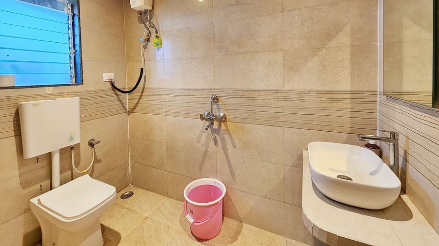 Bathroom of Pool View Standard Room at The Kanila Resort featuring a toilet, sink area and a bucket.
